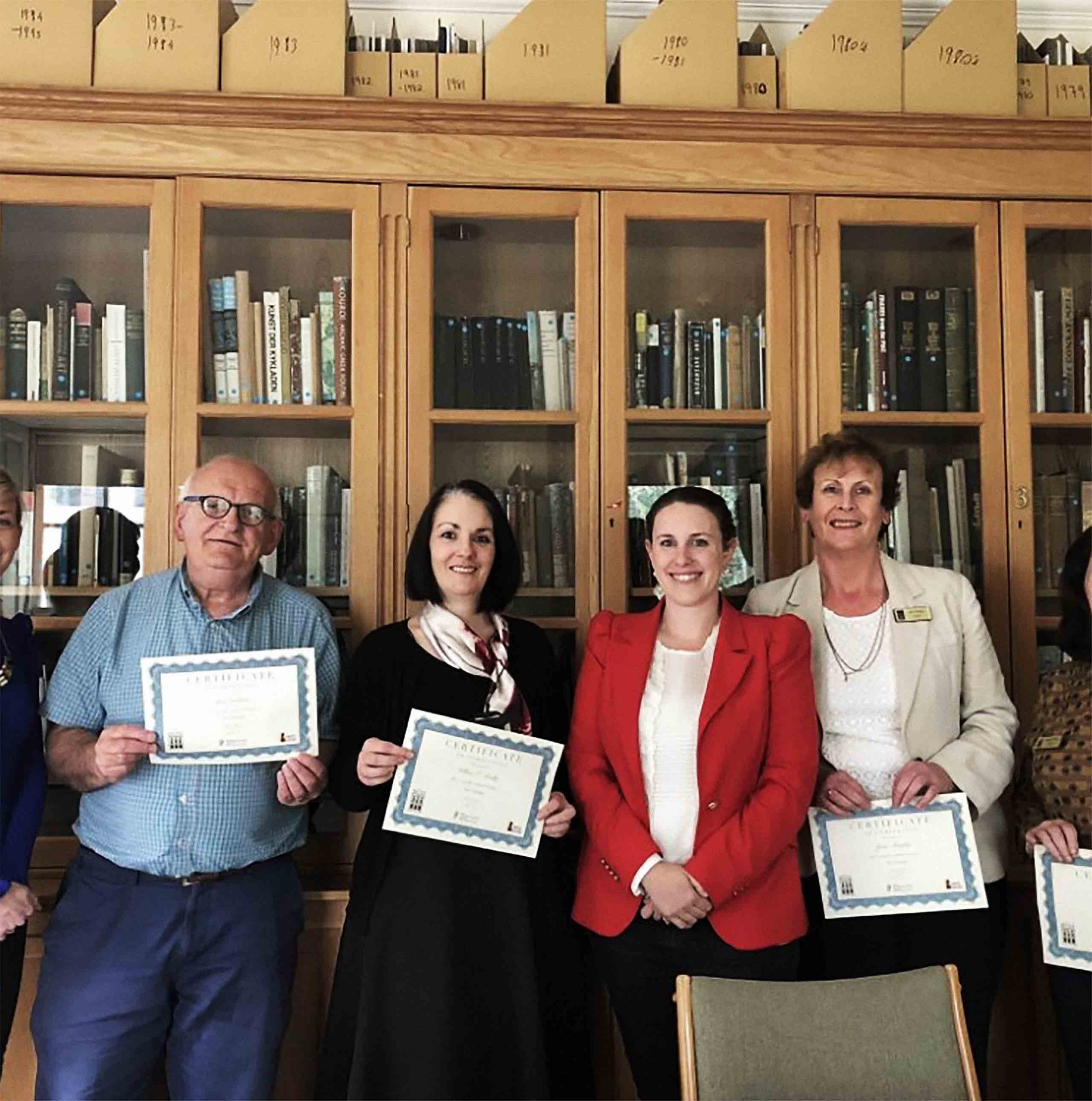 Become a docent. Hunt museum docents standing beside each other with certificates. Become a docent