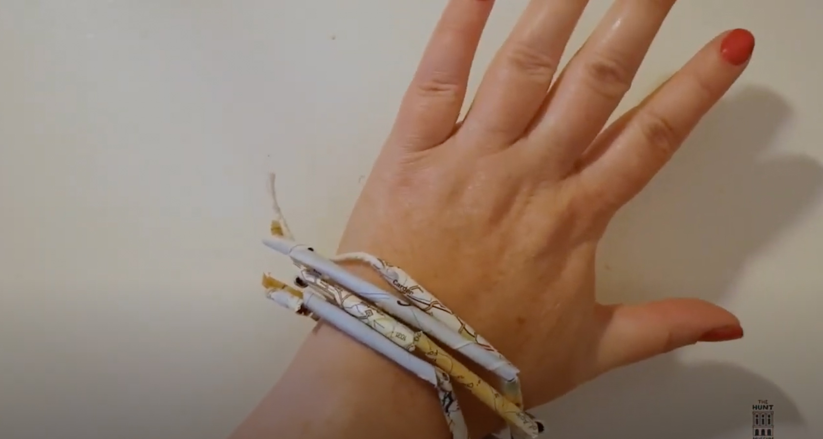 Paper Jewellery. Image of a child's hand with paper bracelets around their wrist