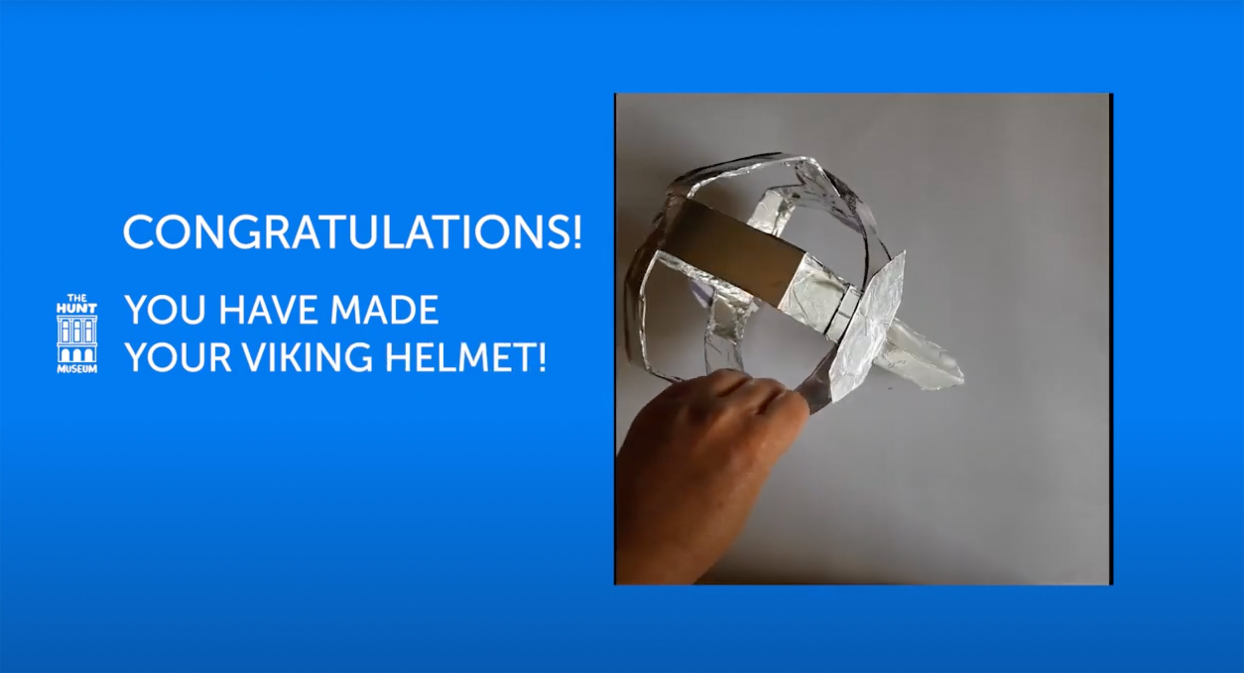 Image of a hand holding a DIY Viking helmet made of card and wrapped in tinfoil. The image is on a blue background with the title 